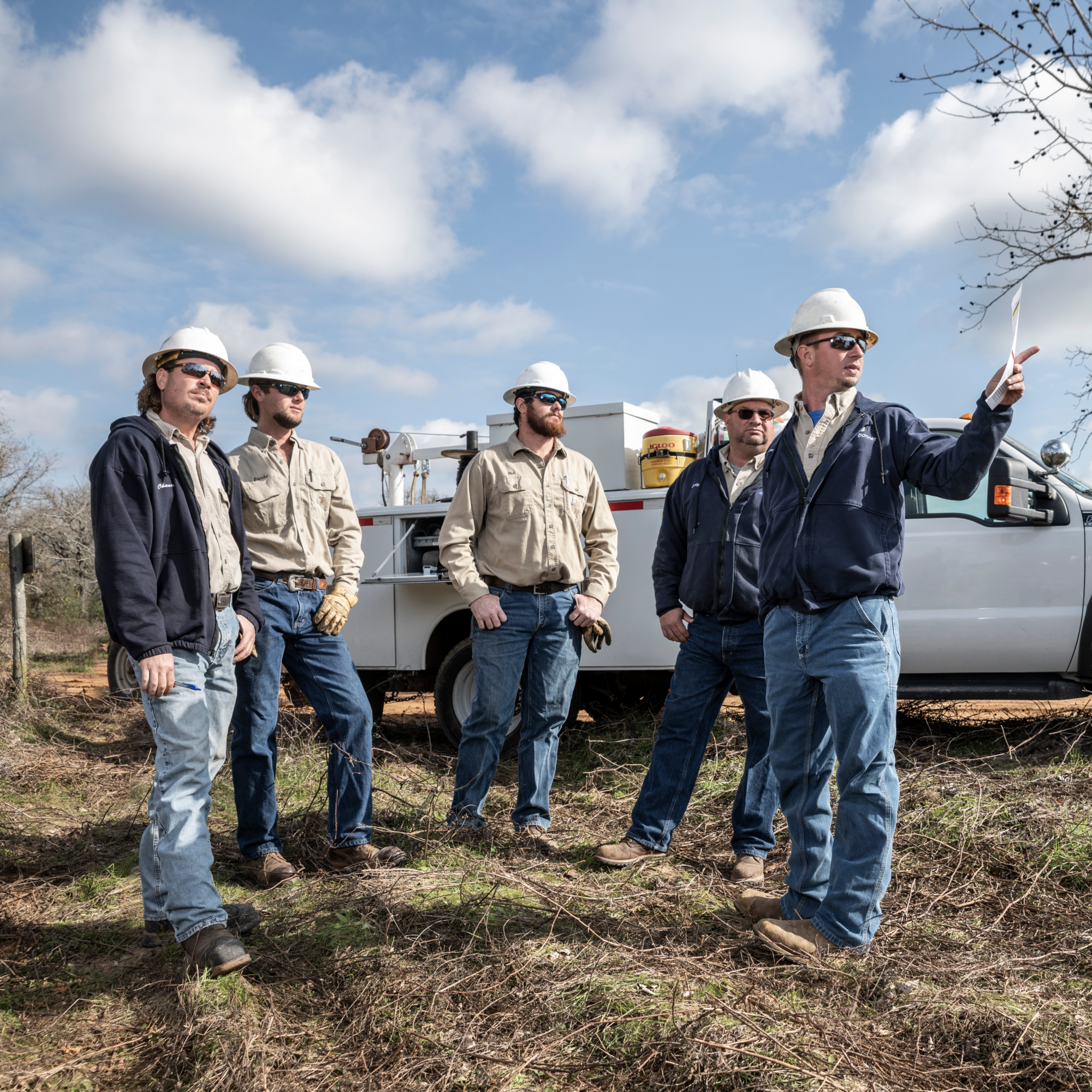 lineworker grew huddling with one man pointing