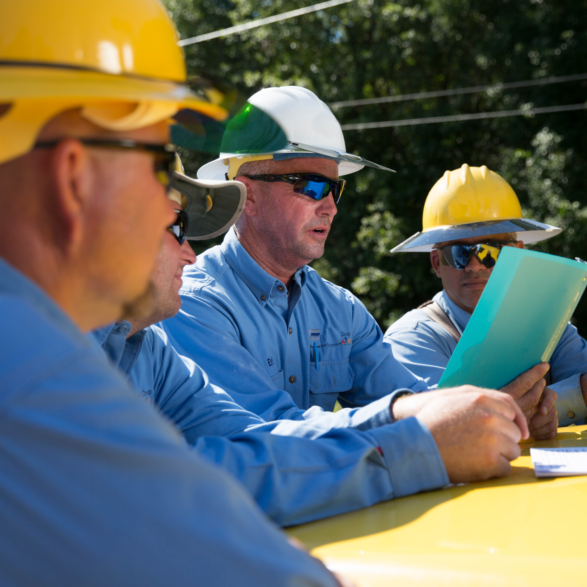 lineworkers in hard hats meeting